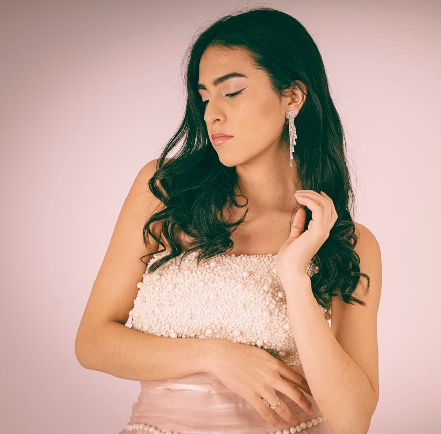 Sophisticated portrait of a woman in a pearl-adorned dress with elegant earrings, showcasing modern femininity.