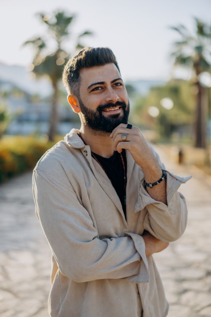 Portrait of smiling man with beard outdoors on a sunny day.